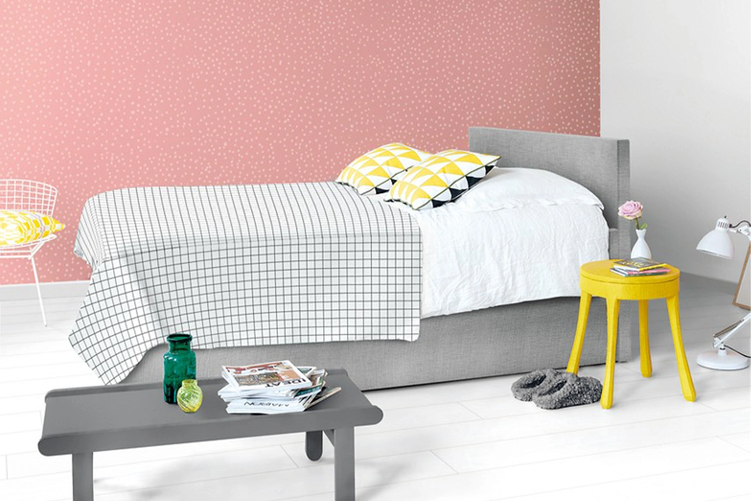 Pokój dziecka z jasną podłogą i szarym łóżkiem przy pastelowej ścianie